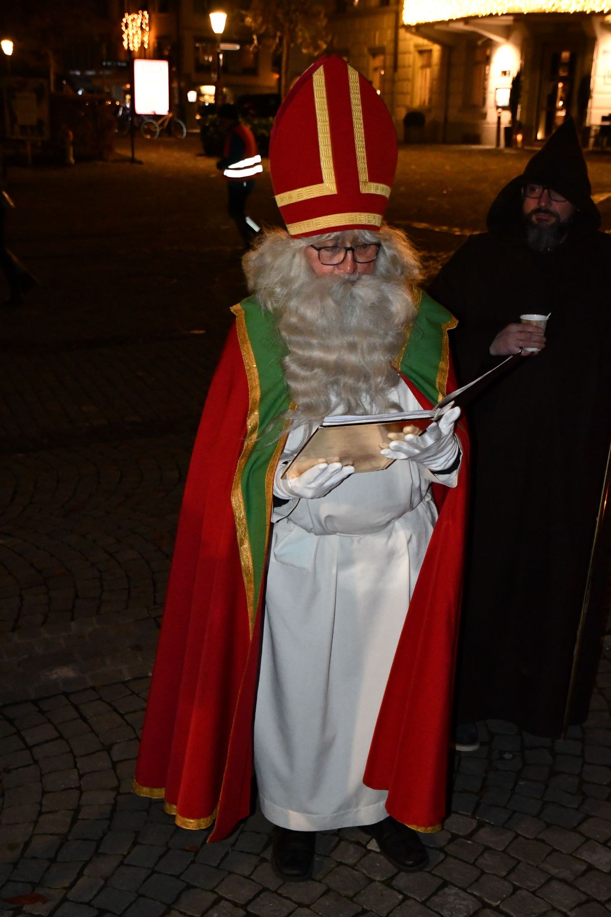 Der Samichlaus im roten Bischofsmantel mit goldenem Buch bei einem Hausbesuch in Zug